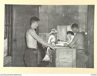 LAE, NEW GUINEA. 1944-10-04. PERSONNEL OF THE NEW GUINEA DETACHMENT OF THE AUSTRALIAN ARMY CANTEENS SERVICE BULK STORE CHECKING CASES OF BEER BEFORE ISSUING IF FROM THE UNIT BULK TORE. IDENTIFIED ..