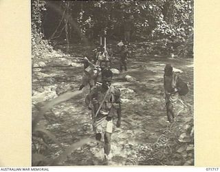 SINGORKAI - WEBER POINT AREA, NEW GUINEA, 1944-03-21. CARRIERS, PROTECTED BY MEMBERS OF C COMPANY PAPUAN INFANTRY BATTALION, FORD THE YUPNA RIVER