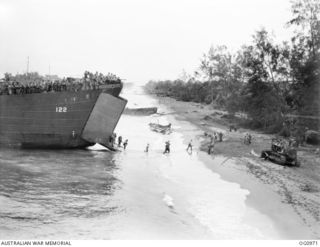 AITAPE AREA, NORTH EAST NEW GUINEA. C. 1944-04-22. ALL ASHORE, A TROOPS AND EQUIPMENT LADEN LANDING SHIP, TANK (LST) NOSES ITS WAY TO THE SANDY BEACHES AT KORAKO VILLAGE AND ANOTHER SUCCESSFUL ..