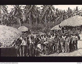 KAIAPIT, NEW GUINEA. 1943-09-26. TROOPS LINED UP FOR A CUP OF TEA AS SOON AS THE YOUNG MEN'S CHRISTIAN ASSOCIATION AND THE AUSTRALIAN COMFORTS FUND CANTEEN OPENED IN THE 21ST AUSTRALIAN INFANTRY ..