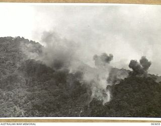 FARIA RIVER, NEW GUINEA. 1944-01-20. SMOKE RISING FROM JAPANESE POSITIONS ACROSS MAIN CREEK, AFTER A STRIKE BY ALLIED MITCHELL BOMBERS