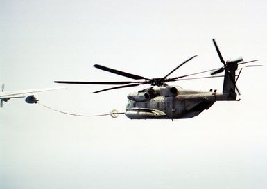 A US Marine CH-53E Sea Stallion helicopter assigned to the 22nd Marine Expeditionary Unit (MEU), refuels from a US Military support aircraft, while operating from the flight deck of the US Navy's amphibious assault ship USS GUAM (LPH 9) (not shown). The 2000 marines on board Guam have been operating in coastal waters off the troubled African nation of Liberia, assisting in evacuation efforts in support of Operation ASSURED RESPONSE