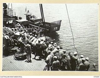 HOSKINS, NEW BRITAIN. 1944-10-13. THE BAND OF THE 36TH AUSTRALIAN INFANTRY BATTALION (IN BARGES) FAREWELLING MEMBERS OF THE UNITED STATES 40TH INFANTRY DIVISION AS THEY LEAVE FOR CAPE GLOUCESTER ..
