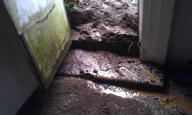 Mud enters the front door of a house after a severe storm and flooding in American Samoa in July-August 2014.