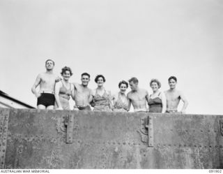 LAE, NEW GUINEA, 1945-05-18. PERSONNEL FROM THE AUSTRALIAN WOMEN'S ARMY SERVICE BARRACKS, WITH TROOPS, ON THE TOP DECK OF THE "MALAHANG WRECK", A DERELICT JAPANESE SHIP NOW LYING ON MALAHANG BEACH. ..