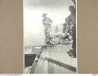 TERAPO, NEW GUINEA, 1943-09-16. SERGEANT R. HAYMAN, AUSTRALIAN MOVEMENT CONTROL, SUPERVISING THE DISCHARGE OF CARGO FROM THE "MULIAMA" TO A LANDING CRAFT VEHICLE ANCHORED OFF THE LAKEKAMU RIVER