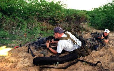 Marines from 3rd Battalion, 3rd Marines, India Company, fire a machine gun using blanks while role-playing as an opposing force defending a third-world county at Pacific Missile Range Facility, Barking Sands, Kauai, Hawaii, against Marines from 11th Marine Expeditionary Unit, Camp Pendleton, California, during RIMPAC 96. The 11th MEU amphibious assault involved Navy and Marine air, ground and sea forces for training as a combined amphibious assault force