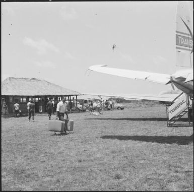 Passengers standing near an airstrip, New Caledonia, 1967 / Michael Terry