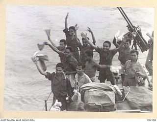 TINIAN, BOUGAINVILLE. 1945-07-18. PASSENGERS ABOARD THE ALLIED INTELLIGENCE BUREAU MOTOR LAUNCH ML1327, WAVING FAREWELL TO NATIVES OF THE ALLIED INTELLIGENCE BUREAU, ON SHORE, AS THE VESSEL LEAVES ..