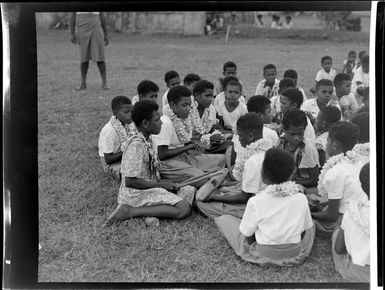 A group of girls sitting with a drum at the meke, Vuda village, Fiji