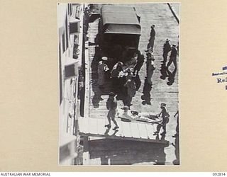 LAE, NEW GUINEA. 1945-06-09. PATIENTS OF 2/7 GENERAL HOSPITAL BEING UNLOADED FROM AMBULANCES AT MILFORD HAVEN WHARF FOR EMBARKATION ON THE HOSPITAL SHIP MANUNDA