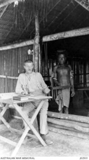 NEW IRELAND, NEW GUINEA. 1917. F.O. CUTLER, A DRAFTSMAN ATTACHED TO THE SURVEY CORPS IN NEW IRELAND, NEW GUINEA, PLOTTING FROM FIELD NOTES. (DONATED BY F.O. CUTLER.)