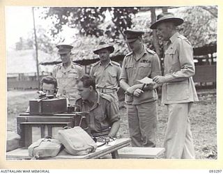 NADZAB AREA, NEW GUINEA, 1945-06-27. HIS ROYAL HIGHNESS, THE DUKE OF GLOUCESTER, GOVERNOR GENERAL OF AUSTRALIA (3) WATCHING CPL F.H. FOWLER (5) AND SGT W.T. PIKE (6), OPERATING A FIELD WIRELESS ..