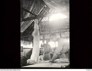 VIVIGANI, GOODENOUGH ISLAND, PAPUA. C. 1943-10. AT NO. 30 BEAUFIGHTER SQUADRON RAAF, PARACHUTE SECTION, PARACHUTES ARE HUNG UP FOR DRYING AS SOON AS THEY ARE HANDED IN FOR INSPECTION. THERE ARE ..