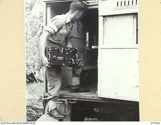 KATIKA, NEW GUINEA. 1944-03-31. NX65187 SIGNALMAN C. STRAHAN, B AUSTRALIA CORPS SIGNALS, CARRYING THE RECEIVER UNIT OF THE 188F, (UNITED STATES ARMY 191F), WIRELESS TRANSMITTER-RECEIVER FOR ..