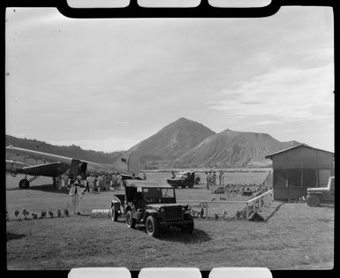 Mt Tavurvur (Matupit) in the background, with a Qantas Empire Airways aeroplane in the foreground, Rabaul, New Britain, Papua New Guinea