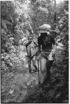 A European woman walking up stream with Kwaio boy