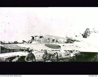 WEWAK, NEW GUINEA, 1945-05. REMAINS OF THE JAPANESE AIRFORCE. LEFT: SERGEANT C.C. ROBERTSON, AIF, 'M' SPECIAL UNIT, ALLIED INTELLIGIENCE BUREAU. RIGHT: PRIVATE LLOYD GUARD, AIF, ON LOAN TO 'M' ..