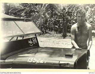 RAMU VALLEY, NEW GUINEA, 1944-03-21. NX108029 PRIVATE A.J. DANIELS (1), OF HEADQUARTERS, 7TH DIVISION, AT WORK ON HIS JEEP