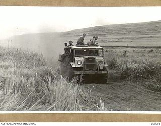 SIALUM AREA, HUON PENINSULA, NEW GUINEA. 1944-01-14. A THREE TON TRUCK OF THE 9TH DIVISION MOVING ALONG A DUSTY TRACK IN THE SIALUM AREA