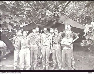 RABAUL, NEW BRITAIN, 1945-12-12. MEMBERS OF 11 DIVISION TRANSPORT SECTION STANDING OUTSIDE THE TRANSPORT OFFICE