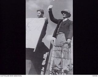 SYDNEY, NSW. 1946-05-16. RELATIVES WAVE TO LONG SERVICE PERSONNEL RETURNING HOME, AS THEY ARRIVE AT CIRCULAR QUAY ON THE TROOPSHIP CANBERRA, FROM RABAUL. FIVE HUNDRED PERSONNEL WERE ABOARD