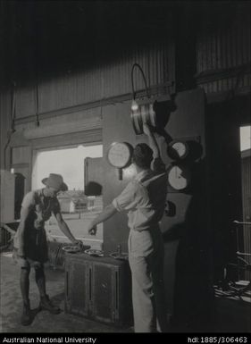 Workers operating mill machinery