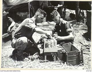 DALLMAN RIVER, NEW GUINEA, 1944-02-23. MEMBERS OF THE 2/14TH FIELD REGIMENT WORKING ON A WIRELESS SET. IDENTIFIED PERSONNEL ARE: N230644 GUNNER G. MINTER (1); VX109854 GUNNER L.J. SPENCER (2)