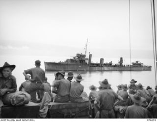 JACQUINOT BAY, NEW BRITAIN. 1944-11-04. MEMBERS OF B COMPANY, 14/32ND INFANTRY BATTALION WATCH ONE OF THEIR ESCORT VESSELS, THE HMAS "VENDETTA" MOVING INTO THE BAY