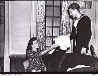 LAE, NEW GUINEA, 1945-12-18. CORPORAL G. A. ROBINS, (MABEL CRUN) (1) AND SERGEANT A. WHITE (EARL OF HARPERDON) (2) PLAYERS OF DETACHMENT 12 ENTERTAINMENT UNIT, IN A SCENE FROM THE WAR-TIME COMEDY ..