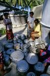 During water shortage, women place their water containers outside a communal, locked, tank