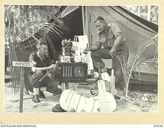 MILILAT, NEW GUINEA. 1944-08-06. QX28779 PRIVATE P.J. HORAN (1) AND NX114181 CAPTAIN A.E. RICHARDS (2) UNPACKING AMENITIES EQUIPMENT WHICH HAS JUST ARRIVED AT HEADQUARTERS, 5TH DIVISION