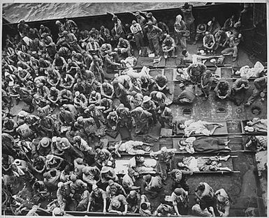 A further indication that not all Japanese fight to the death is this bag of 221 Nip prisoners of war. Sprawled on the deck of an Landing Craft Tank, they are being brought to a Coast Guard-manned troop transport at Guam for transfer to Pearl Harbor.