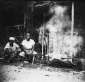 Natives of Bugainville roasting a pig on a spit, 1944