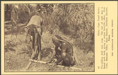 Fire making with cane strap, Oinji Tribe, Mamama Valley, Buna District, Northern Division, Papua / photo. Capt. Frank Hurley