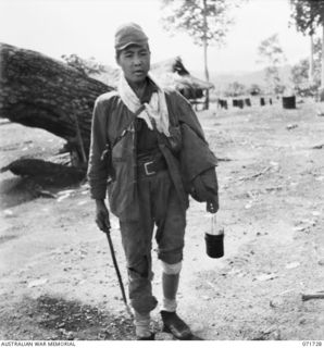 WASU, PAPUA, 1944-03-25. A JAPANESE PRISONER OF WAR DRESSED IN SCRAPS OF CLOTHING WHICH WERE FILTHY, PREPARES TO LEAVE THE COMPOUND AT HEADQUARTERS PAPUAN INFANTRY BRIGADE FOR KILIGIA