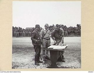 CAPE WOM, NEW GUINEA, 1945-09-13. SCENE AT THE SURRENDER TABLE DURING THE SURRENDER CEREMONY HELD AT CAPE WOM AIRSTRIP. LIEUTENANT-GENERAL H. ADACHI, COMMANDER 18 JAPANESE ARMY IN NEW GUINEA, ..