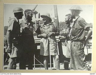 Port Moresby, New Guinea. 1942-04-12. Lieutenant Colonel E. T. Brennan, DSO, MC, Assistant Director of Medical Services, 8th Military District (centre) talking with survivors of the Rabaul Garrison ..