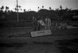 Guam, Harrison Forman, the photographer, and a military officer next to a sign for 'Guam, M.I.'
