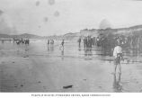 Men, women and children standing and playing on the beach, Newport, Oregon, between 1895 and 1905