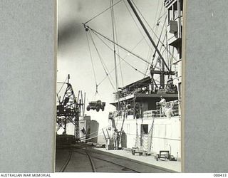 CAIRNS, QUEENSLAND. 1945-03-25. A HEADQUARTERS 26 INFANTRY BRIGADE JEEP IS LOADED ABOARD THE DUTCH VESSEL VAN HEUTSZ DURING EMBARKATION TO MILNE BAY