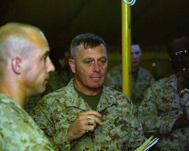 US Marine Corps (USMC) Brigadier General (BGEN) Jerry C. McAbee (center), Commanding General (CG), Marine Corps Base (MCB) Hawaii; Deputy CG, US Marine Forces, Pacific (MARFORPAC); Deputy CG, US Marine Forces Central Command (MARCENT); and Deputy CG, III Marine Expeditionary Force (MEF), Hawaii; visits with 1ST Marine Division (MARDIV) Marines at Camp Udairi, Kuwait (KWT), as part of his official tour of USMC units in Kuwait and to specifically discuss the 1ST MARDIVs movement in Iraq (IRQ) during Operation IRAQI FREEDOM. (SUBSTANDARD)