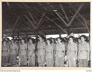 LAE, NEW GUINEA. 1945-05-11. AUSTRALIAN WOMEN'S ARMY SERVICE IN THE RECREATION HUT AT THE NEWLY COMPLETED AUSTRALIAN WOMEN'S ARMY SERVICE BARRACKS IN BUTIBUM ROAD, STANDING TO ATTENDING UPON THE ..