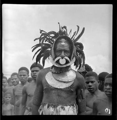 Local man in traditional dress, with a group of local men, Kerowagi, Simbu, Papua New Guinea