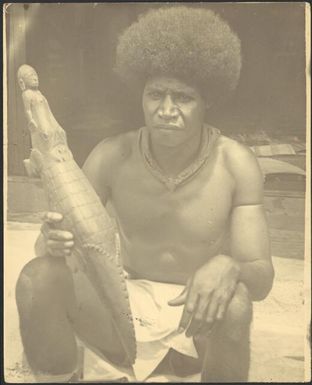 Sepik man with a carving of a crocodile at Awar, Sepik River, New Guinea, 1935 / Sarah Chinnery