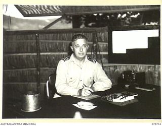 LANGEMAK BAY, NEW GUINEA. 1944-08-21. COMMANDER N.S. PIXLEY, ROYAL AUSTRALIAN NAVAL RESERVE, NAVAL OFFICER- IN- CHARGE, RAN STAFF OFFICE, WORKING AT HIS DESK