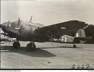 JACQUINOT BAY, NEW BRITAIN. 1945-04-12. THE STORPEDO, THE CONTAINER WHICH IS USED TO DROP SUPPLIES TO AUSTRALIAN ARMY MEN FROM THE AIR IN NEW BRITAIN, IS HUNG FROM THE WING OF A BEAUFORT BOMBER ..