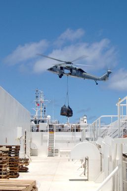 A US Navy (USN) MH-60 Knighthawk helicopter from Guam-based USN Helicopter Sea Combat Squadron 25 (HSC-25) conduct Vertical Replenishment (VERTREP) operations on the flight deck of the USN Military Sealift Command (MSC) Mercy Class Hospital Ship (AH) USNS MERCY. The MERCY is currently on a five-month deployment in the Pacific Ocean. The ship will participate in humanitarian assistance and civic action programs with civilian organizations at several islands in the Pacific Region. The MERCY is capable of supporting medical and humanitarian assistance needs. It is configured with special medical equipmentand the ship has multi-specialized medical teams that can provide a range of services...