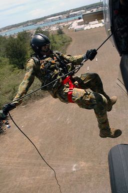 A Royal Australian Navy (RAN) Sailor rappels from the door of a US Navy (USN) MH-60S Sea Hawk helicopter form Helicopter Sea Combat Squadron 25 (HSC-25), during a Helicopter Rope Suspension Technique (HRST) training exercise held at Polaris Point, Santa Rita Naval Base, Guam (GU), during the Annual Multi-national Explosive Ordnance Disposal (EOD) Exercise known as TRICARB 2006." The Exercise brings together EOD Units from the US, Australia and Singapore