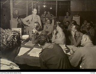 Lae, New Guinea. c. 1944-07-25. Lieutenant General S. G. Savige, General Officer Commanding 2 Corps (1), introducing Dr Thomas Wood, author of the book "Cobbers", to members of the Writer's Club ..